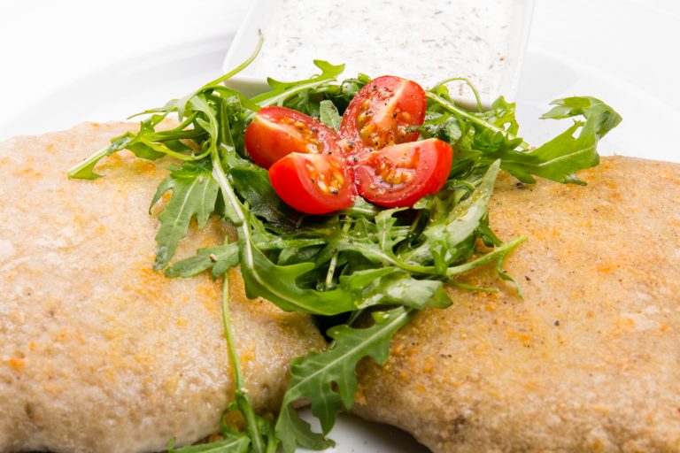 Vegetariánske jedlo s rukolou, paradajkami a omáčkou
